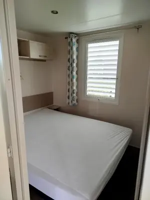 a bed in a room with a window at Mobil home dans camping 3 étoiles in Saint-Papoul