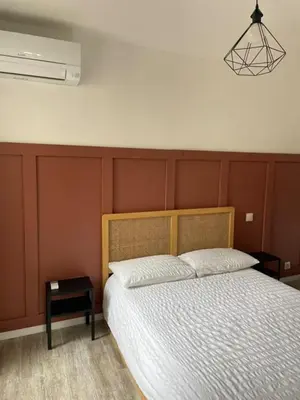 a bedroom with a bed and a nightstand next to it at Les Halles d'Isa et Thomas in Narbonne