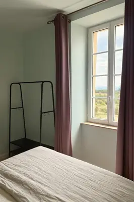 a bedroom with a bed and a window at Maison de maître avec piscine et vue in Villardonnel