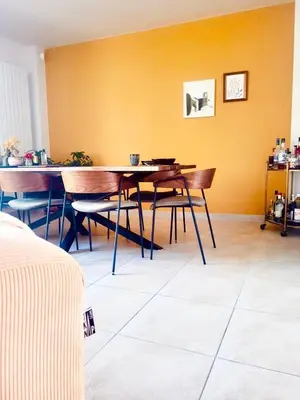 a dining room with two tables and a yellow wall at Maison de maître avec piscine et vue in Villardonnel