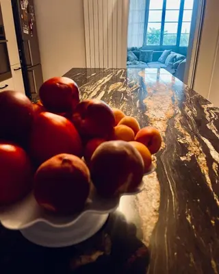 a plate of tomatoes sitting on a kitchen counter at Maison de maître avec piscine et vue in Villardonnel