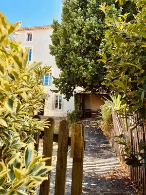 a wooden path leading to a building with a fence at Maison de maître avec piscine et vue in Villardonnel