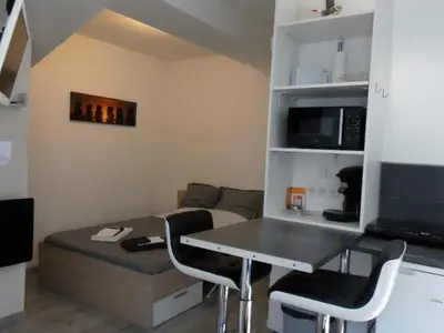 a living room with a table and a couch at Hebergement privatif coeur de village in Maury