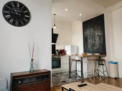 a kitchen with a clock on the wall and a table at Casa Mistral in Carcassonne