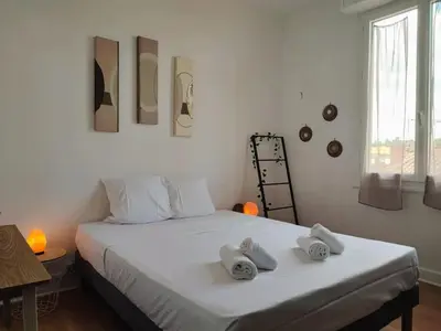 a bedroom with a white bed with towels on it at Casa Mistral in Carcassonne