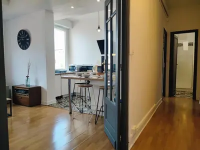 a living room with a table and a clock on the wall at Casa Mistral in Carcassonne