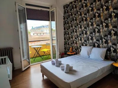a bedroom with a bed with a wall with birds on it at Casa Mistral in Carcassonne