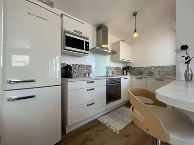 a kitchen with a white refrigerator and a table at Très joli chalet privatif à Gruissan - Plage à 50 m - GN600-280 in Gruissan