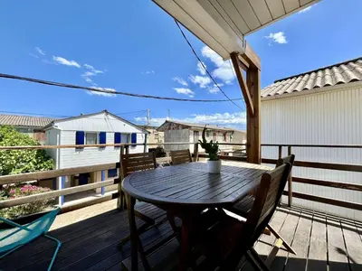 a wooden deck with a table and chairs on it at Très joli chalet privatif à Gruissan - Plage à 50 m - GN600-280 in Gruissan