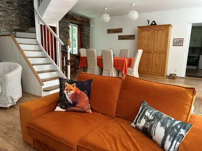an orange couch with a fox on it in a living room at Cottage by River with Spa near Carcassonne in Caudebronde