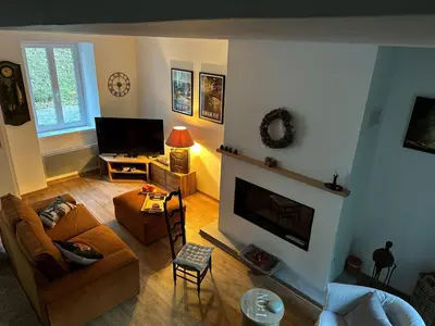 a living room with a couch and a fireplace at Cottage by River with Spa near Carcassonne in Caudebronde