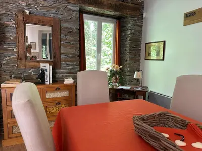 a dining room with a table and a mirror at Cottage by River with Spa near Carcassonne in Caudebronde