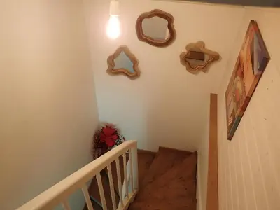 a hallway with a stairway with a bunch of mirrors on the wall at Cottage by River with Spa near Carcassonne in Caudebronde