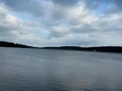a large body of water with wind turbines in the distance at Cottage by River with Spa near Carcassonne in Caudebronde