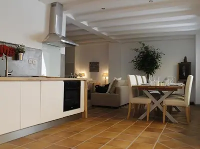 a kitchen and living room with a table and a couch at Maison Bacou cité 1 in Carcassonne