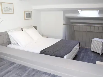 a bedroom with a large white bed with white sheets at Maison Bacou cité 1 in Carcassonne