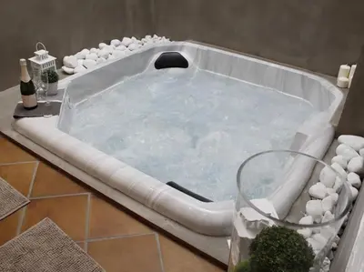 a jacuzzi tub in a bathroom with a glass of water at Maison Bacou cité 1 in Carcassonne
