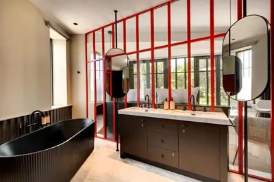 a bathroom with a tub and a large mirror at La Jasso Hôtel, Maison de Famille in Carcassonne