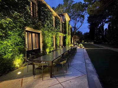 a long table and chairs next to a building at La Jasso Hôtel, Maison de Famille in Carcassonne