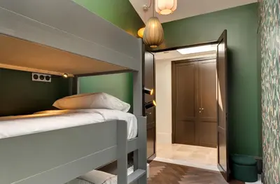 a bedroom with green walls and a bunk bed at La Jasso Hôtel, Maison de Famille in Carcassonne