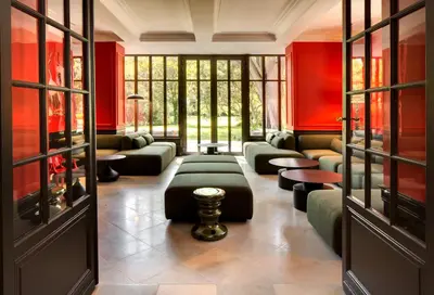 a living room with red walls and green furniture at La Jasso Hôtel, Maison de Famille in Carcassonne