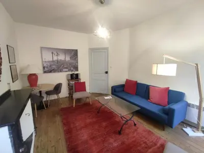 a living room with a blue couch and a table at Carcassonne Town House, Rue Barbès in Carcassonne