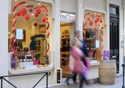 a woman walking past a cosmetics store with windows at Carcassonne Town House, Rue Barbès in Carcassonne