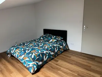 a bed with a colorful blanket in a bedroom at Apparently cozy - wifi - Netflix - air-conditioned in Labastide-dʼAnjou