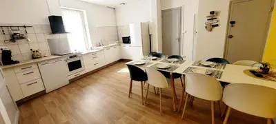 a kitchen with a long table and chairs in it at Logement spacieux in Carcassonne