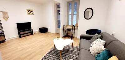a living room with a couch and a tv at Logement spacieux in Carcassonne