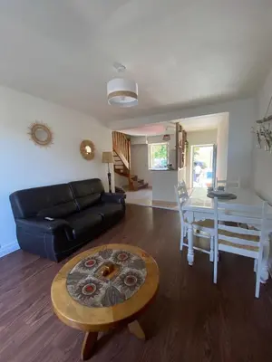 a living room with a black couch and a table at Maison entre champs et clochers in Massaguel