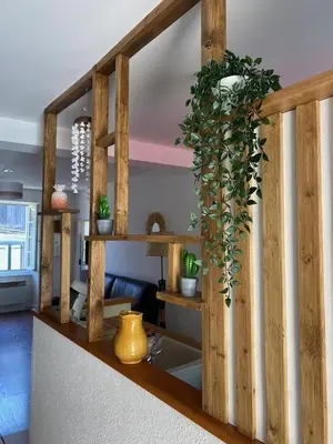 a living room with a wooden staircase with potted plants at Maison entre champs et clochers in Massaguel