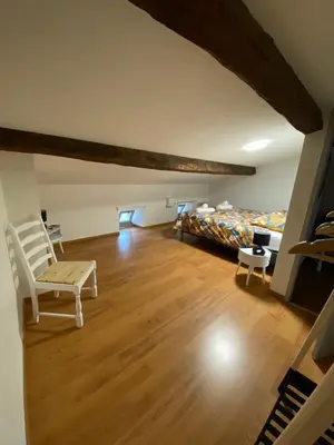 a bedroom with a bed and a wooden floor at Maison entre champs et clochers in Massaguel