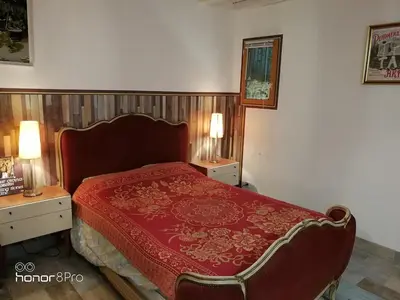 a bedroom with a red bed with two night stands at la cassignolette in Castelnaudary