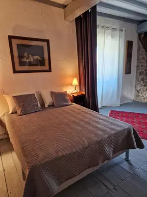 a bedroom with a large bed in a room at Le Vieux Fusil in La Celle-sous-Gouzon