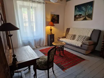 a living room with a couch and a table at Le Vieux Fusil in La Celle-sous-Gouzon