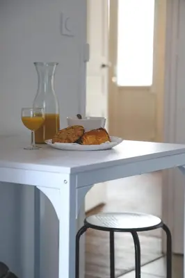 a table with a plate of food and a glass of orange juice at Le Nid Urbain, terrasse, garage et confort in Carcassonne