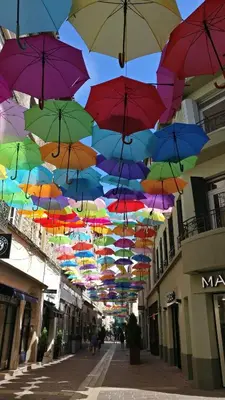 a bunch of umbrellas hanging over a street at Le Nid Urbain, terrasse, garage et confort in Carcassonne