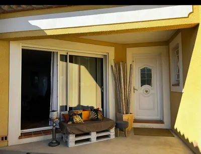 a porch with a couch in front of a door at Le petit cocon de Lolo in Carcassonne
