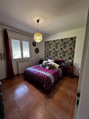 a bedroom with a bed with a purple comforter at Le petit cocon de Lolo in Carcassonne