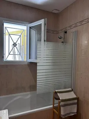 a bathroom with a tub and a window and a sink at Le petit cocon de Lolo in Carcassonne