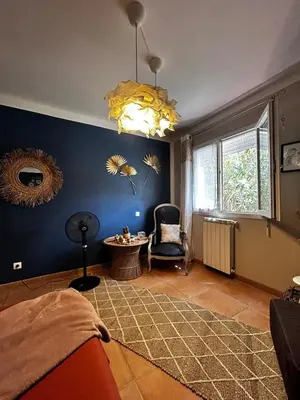 a room with a bed and a chair and a table at Le petit cocon de Lolo in Carcassonne