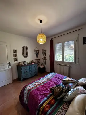 a bedroom with a bed and a blue dresser at Le petit cocon de Lolo in Carcassonne