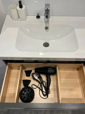 a sink under a counter with someabling under it at La Suite Lauragaise - Studio climatisé in Villefranche-de-Lauragais