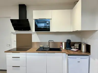 a kitchen with white cabinets and a sink and a microwave at La Suite Lauragaise - Studio climatisé in Villefranche-de-Lauragais