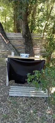 a black tub sitting next to a tree at Hamacs Carbounieros