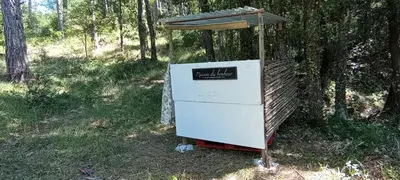 an old refrigerator sitting in the grass next to a tree at Hamacs Carbounieros
