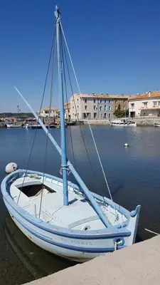 a white boat is docked in the water at Alcôve Marine in Gruissan