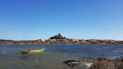 a small boat in the water with an island at Alcôve Marine in Gruissan