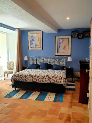 a bedroom with blue walls and a bed with blue pillows at Alcôve Marine in Gruissan